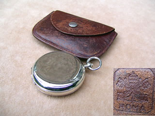 Top view of compass in closed position & pouch impressed with Vatican City insignia
